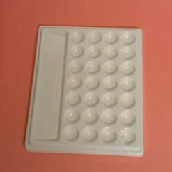 Une Palette En Résine Blanche épaisse Et Ses 28 Trous Plus 1 Grand
